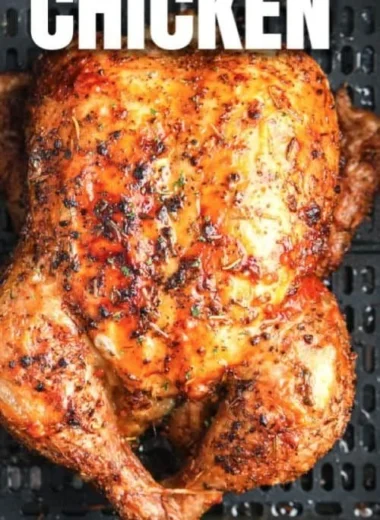 Crispy air fryer whole roasted chicken garnished with herbs on a serving platter