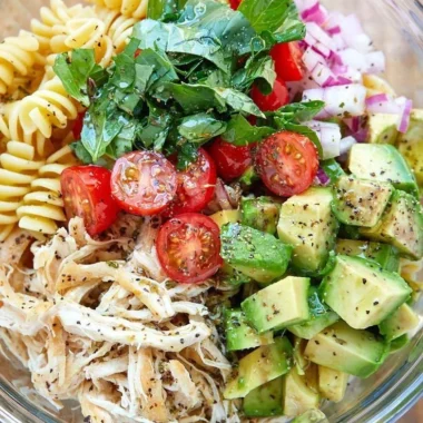 Healthy chicken pasta salad with fresh vegetables and dressing
