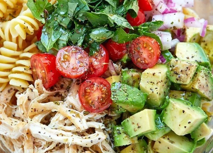 Healthy chicken pasta salad with fresh vegetables and dressing