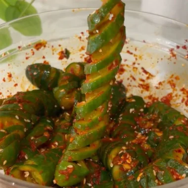 Spiral cucumber salad inspired by Korean flavors, showcasing fresh ingredients and vibrant colors.