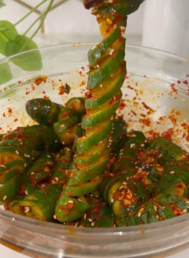 Spiral cucumber salad inspired by Korean flavors, showcasing fresh ingredients and vibrant colors.
