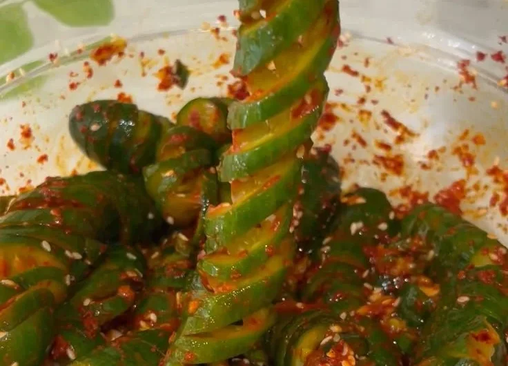 Spiral cucumber salad inspired by Korean flavors, showcasing fresh ingredients and vibrant colors.