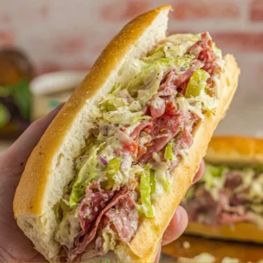 Chopped Italian sandwich with fresh meats, cheeses, and vegetables on a rustic bread