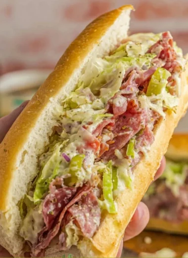Chopped Italian sandwich with fresh meats, cheeses, and vegetables on a rustic bread