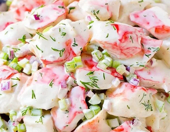 Fresh crab salad with vegetables and dressing in a bowl