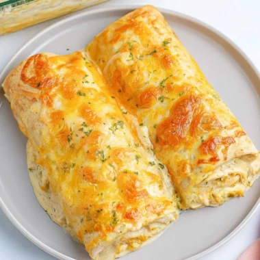 Delicious creamy white chicken enchiladas topped with cheese and cilantro.