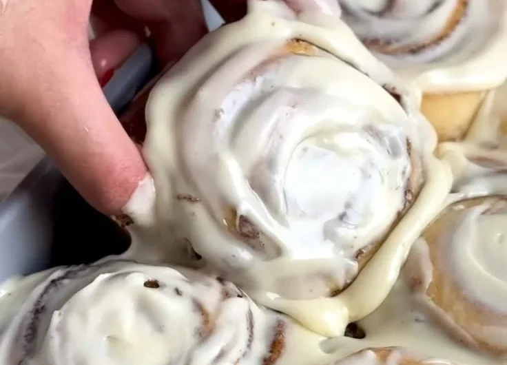 Freshly baked homemade cinnamon rolls topped with icing.