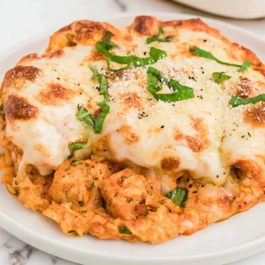 Keto Chicken Parmesan Casserole topped with melted cheese and herbs