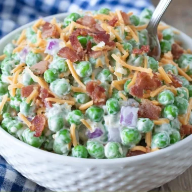 Delicious Old Fashioned Pea Salad served in a bowl, garnished with herbs.
