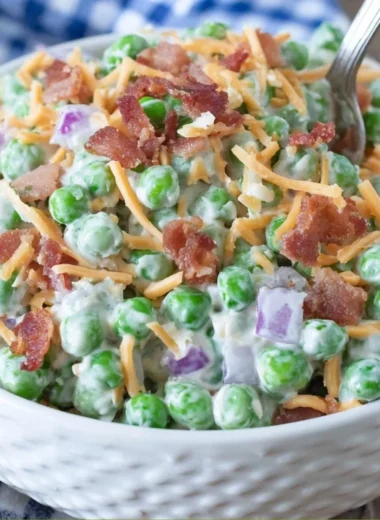 Delicious Old Fashioned Pea Salad served in a bowl, garnished with herbs.