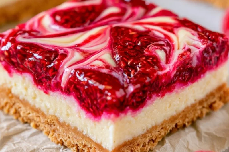 Homemade Raspberry Cheesecake Bars topped with fresh raspberries and a graham cracker crust.