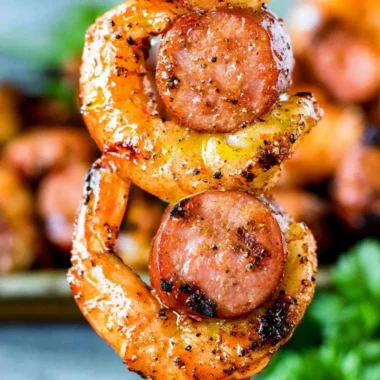 Grilled sausage & shrimp kabobs on skewers, garnished with vegetables.