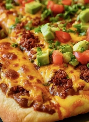 Delicious Taco Pizza topped with beef, veggies, and cheese