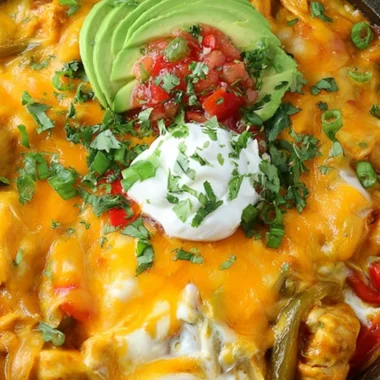 Cheesy chicken fajitas casserole topped with melted cheese and colorful peppers.
