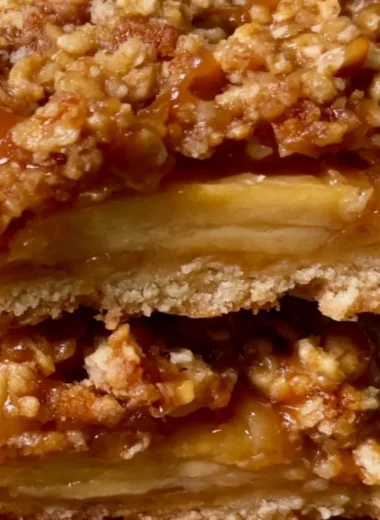 Cozy apple pie bars with a golden crust and apple filling, served on a wooden table.