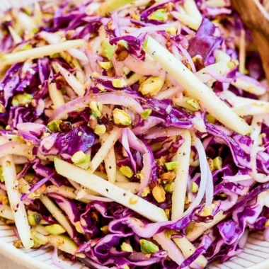 Bowl of cozy cabbage apple slaw with vibrant green cabbage and crisp apple slices