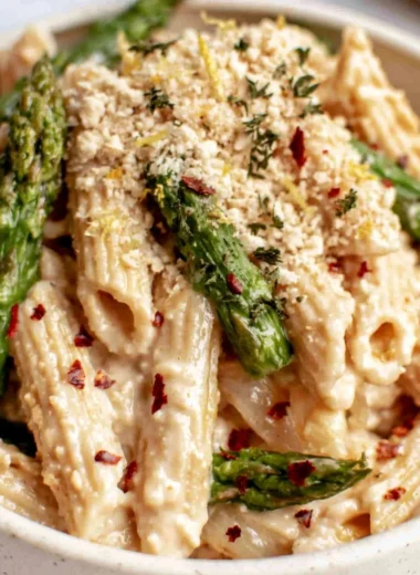 Creamy dairy-free lemon white bean pasta garnished with herbs and lemon zest.