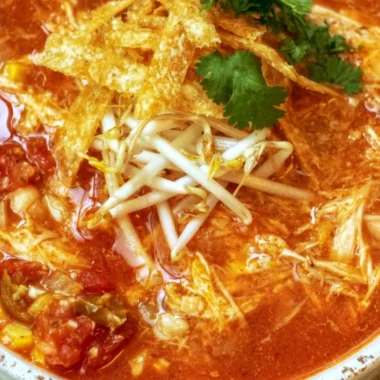 Delicious bowl of Crock Pot Chicken Tortilla Soup garnished with tortilla strips and cilantro.