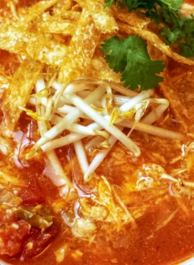 Delicious bowl of Crock Pot Chicken Tortilla Soup garnished with tortilla strips and cilantro.