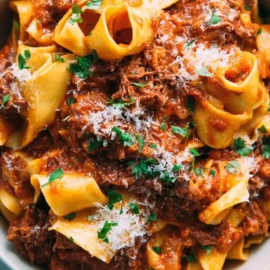 Delicious homemade short rib ragu served over pasta in a rustic bowl.