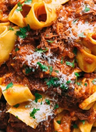 Delicious homemade short rib ragu served over pasta in a rustic bowl.
