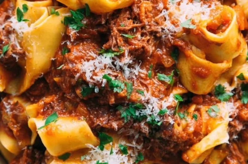 Delicious homemade short rib ragu served over pasta in a rustic bowl.