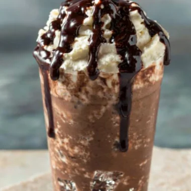 A delicious iced mocha coffee topped with whipped cream and chocolate drizzle.