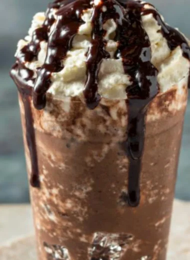 A delicious iced mocha coffee topped with whipped cream and chocolate drizzle.