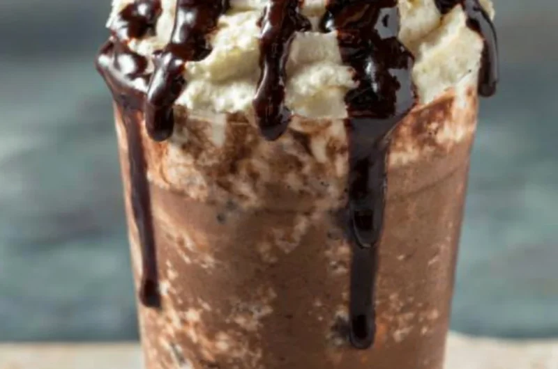 A delicious iced mocha coffee topped with whipped cream and chocolate drizzle.
