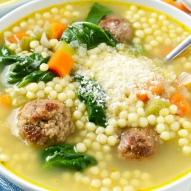 A bowl of Italian Wedding Soup with meatballs and greens