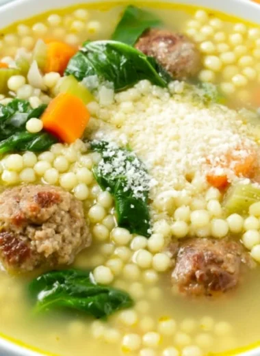 A bowl of Italian Wedding Soup with meatballs and greens