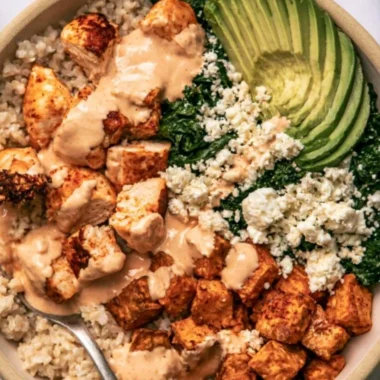 Roasted chicken served over sweet potato rice in a colorful bowl