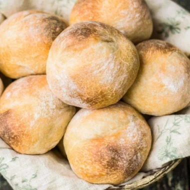 Freshly baked sourdough rolls on a wooden table