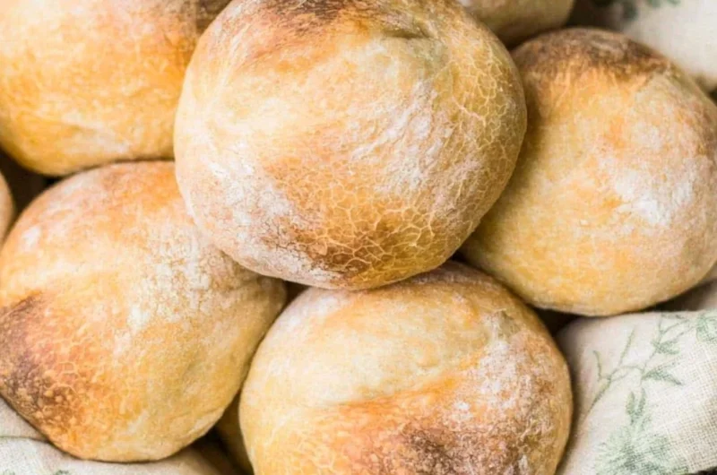 Freshly baked sourdough rolls on a wooden table