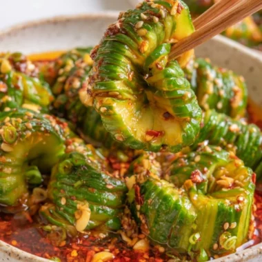 Bowl of spicy Asian cucumber salad with vibrant vegetables and herbs