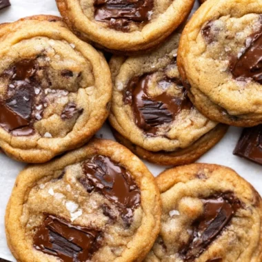 Delicious brown butter chocolate chip cookies on a rustic wooden surface.