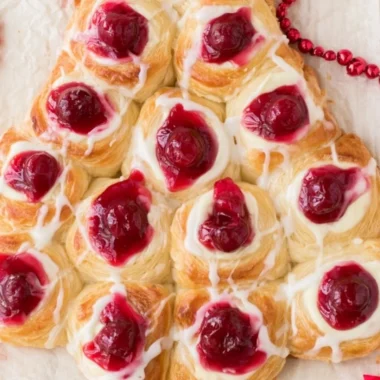 Christmas Tree Danish topped with cream cheese glaze on a festive plate