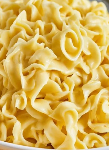 Bowl of cozy creamy cafeteria noodles topped with herbs and spices
