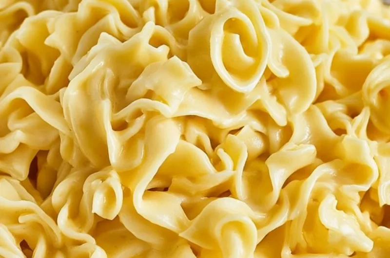 Bowl of cozy creamy cafeteria noodles topped with herbs and spices