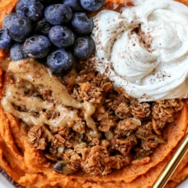 Fluffy sweet potato breakfast bowl topped with nuts and berries