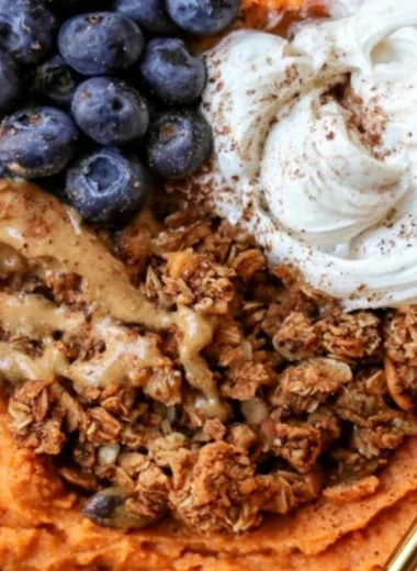 Fluffy sweet potato breakfast bowl topped with nuts and berries