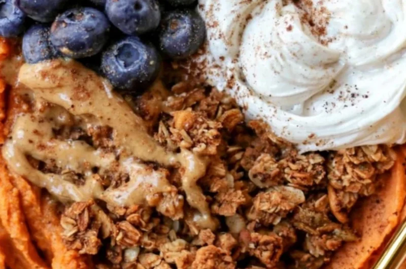 Fluffy sweet potato breakfast bowl topped with nuts and berries