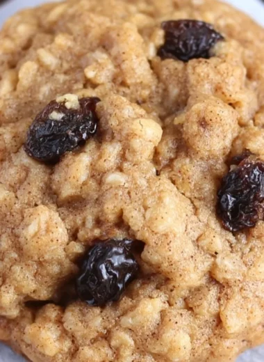 Healthy oatmeal raisin cookies fresh out of the oven, topped with oats and raisins.